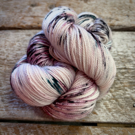 Écheveau de laine teinte à la main – couleur Marbelous Colette – sur fond Naturel (off-white), des speckles rose mauve et sarcelle – base merino fingering